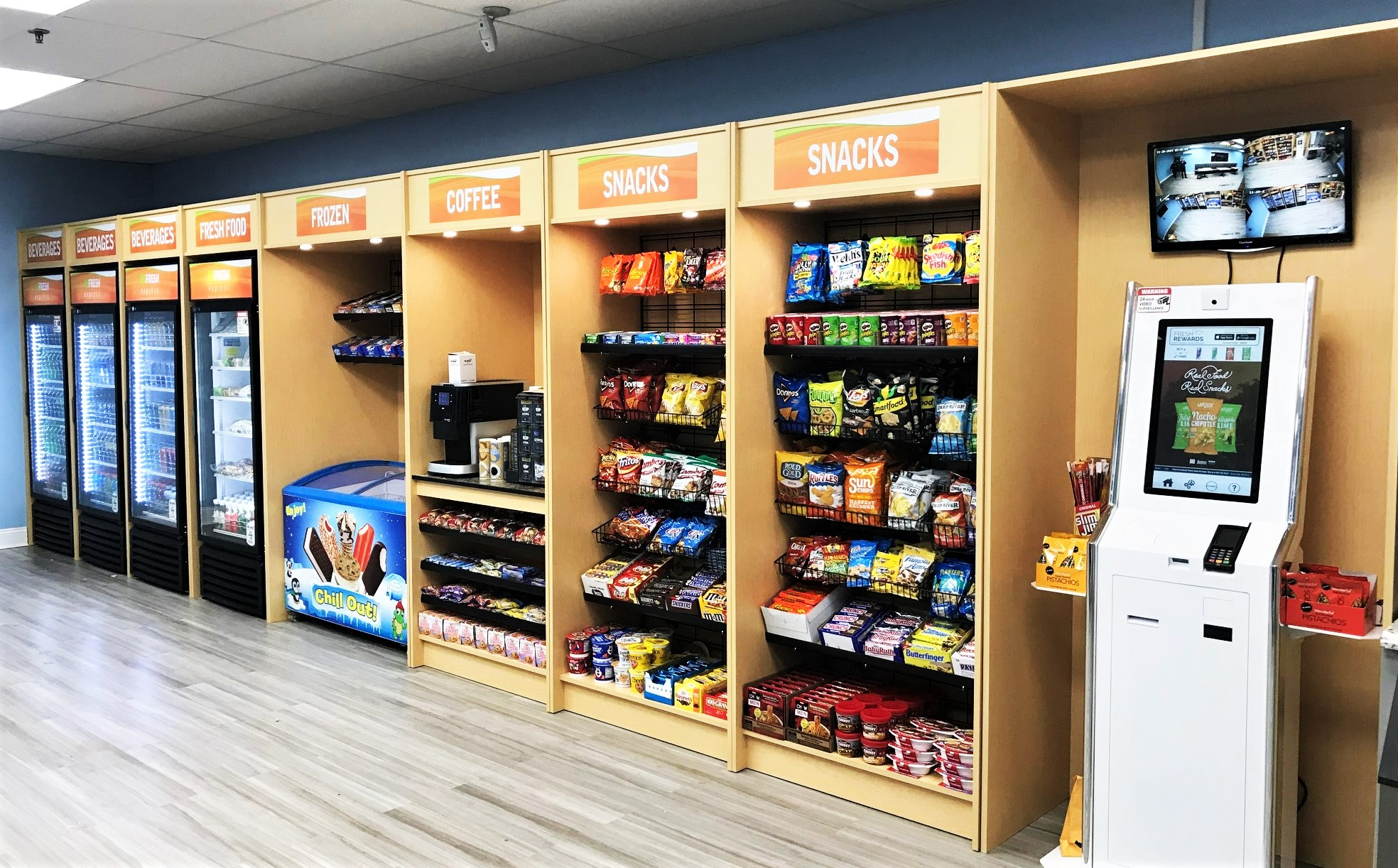 A modern micro market by Allied Vending Inc. featuring refrigerated beverage coolers, snack shelves, and a self-checkout kiosk in a clean office space.